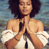 Woman with eyes closed and hands in prayer positiion wearing Ambarya Willpower - Pyrite Mala Bead Set